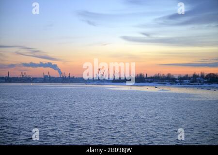 Coucher de soleil rose d'hiver et vue sur le paysage urbain Du Côté de la mer Baltique. Coucher de soleil avec rochers enneigés et paysage de plage. Mer Baltique, hiver Banque D'Images
