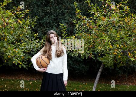 fille jouant au basket-ball après l'école Banque D'Images