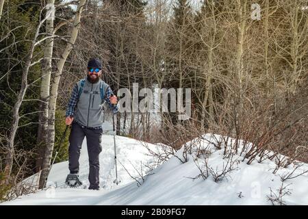 Randonneurs dans les montagnes promenades sur les raquettes. L'homme est seul dans la forêt. Tourisme de montagne d'hiver. Kazakhstan Banque D'Images