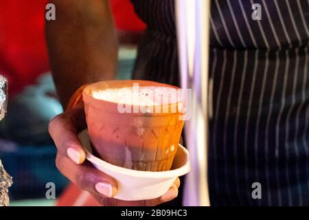 Vendeur indien de nourriture de rue faisant du thé de Chai de masala tandoori en faisant bouillir dans une casserole d'argile chaude dans une casserole de laiton pour faire bouillir le thé Banque D'Images