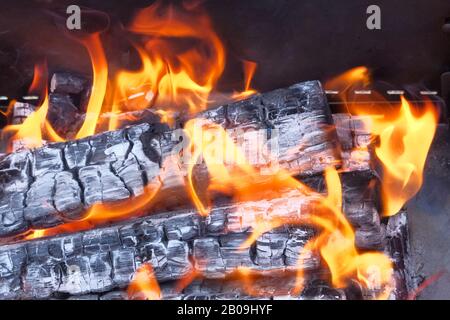 Flamme dans la cheminée à proximité. Flammes, bois brûlant et fumée. Banque D'Images