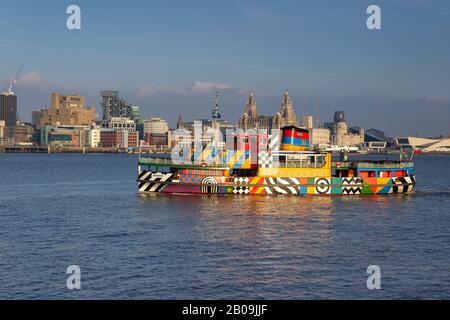 M.V. Snowdrop, ferry Mersey à Dazzle Livery conçu par Sir Peter Blake, contre la ville de Liverpool. Banque D'Images