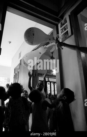 Une ayah, infirmière ou femme de chambre, offrez-vous les enfants d'un peu de plaisir avec des ballons. Dhaka, Bangladesh. Le 11 mai 2007. Banque D'Images