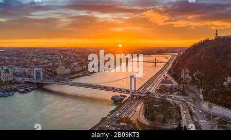 Budapest, Hongrie - lever du soleil doré sur Budapest, avec trafic matinal lourd, pont Elisabeth, pont Liberty et Statue de la liberté Banque D'Images