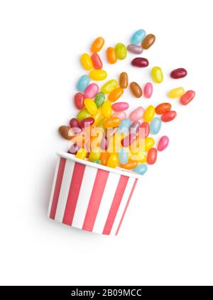 Haricots jaunes fruités. Délicieux haricots de gelée colorés dans une tasse en papier isolée sur fond blanc. Banque D'Images