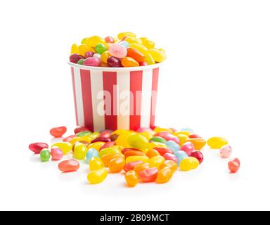 Haricots jaunes fruités. Délicieux haricots de gelée colorés dans une tasse en papier isolée sur fond blanc. Banque D'Images