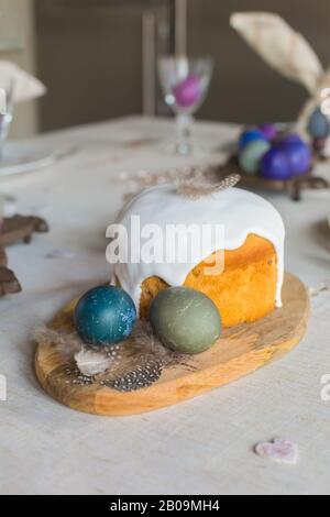 Oeufs de poule de Pâques naturellement teint, gâteau de Pâques, plumes, coeurs en bois sur fond de lin, style rétro vacances de printemps salutation concept de carte postale Banque D'Images