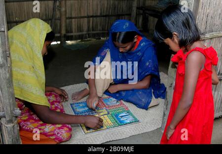 Les filles rurales jouent Ludo (jeu de conseil local) dans un village de Faridpur, au Bangladesh. 3 Octobre 2004. Banque D'Images