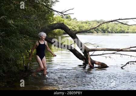 belle femme de 65 ans nageant dans le lac Banque D'Images