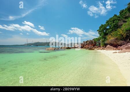 Île tropicale Curieuseat Seychelles - bateaux à voile en arrière-plan Banque D'Images