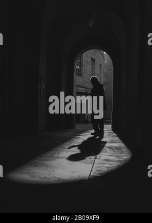 Une personne seule marche à la lumière dans une ville animée. Banque D'Images