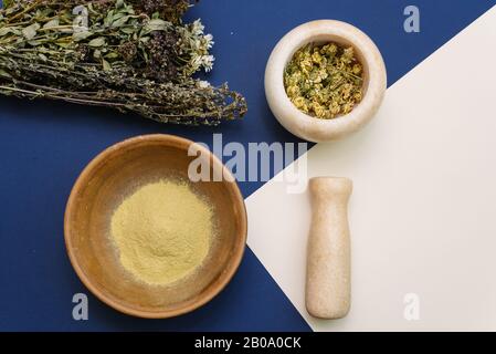 Mélanger les fleurs séchées dans un mortier de marbre pour créer des cosmétiques et gommage pour nettoyer le visage. Argile jaune pour améliorer l'état de la peau. Banque D'Images