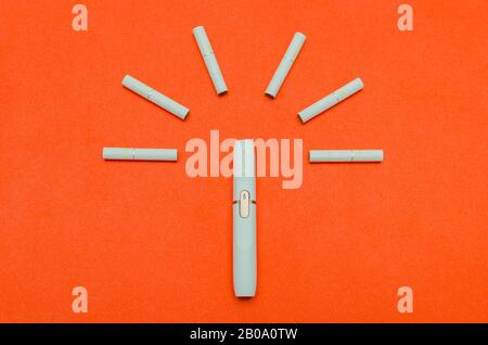 Saint-Pétersbourg, Russie - 08.08.2019: Système alternatif de tabagisme. Iqos. Support et colle sur un fond rouge. Banque D'Images