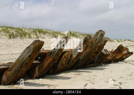 Grande coque en bois vieilli de l'épave exposée sur la plage. Banque D'Images