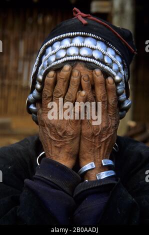 CHINE, XISHUANG BANA, PROVINCE DU YUNAN, VIEILLE FEMME HANI COUVRANT LE VISAGE À NE PAS ÊTRE PHOTOGRAPHIÉ Banque D'Images