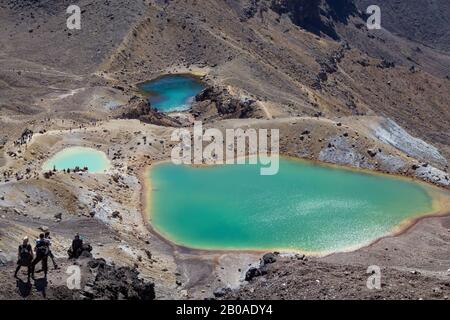 Les personnes qui font de la randonnée à côté des lacs emblématiques d'Emerald au sentier de Tongariro Crossing Banque D'Images