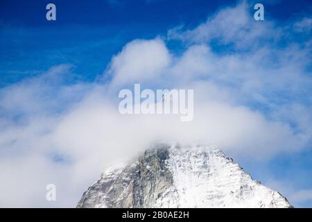 Cervin derrière un nuage blanc par une journée ensoleillée Banque D'Images