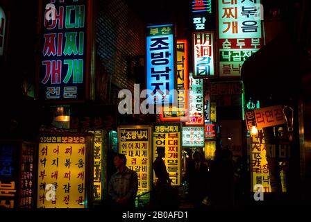 CORÉE, SÉOUL, ZONE COMMERÇANTE MYUNG-DONG LA NUIT AVEC DES ENSEIGNES FLUO COLORÉES Banque D'Images