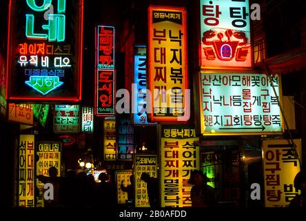 CORÉE, SÉOUL, ZONE COMMERÇANTE MYUNG-DONG LA NUIT AVEC DES ENSEIGNES FLUO COLORÉES Banque D'Images