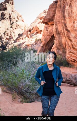 Portrait de la femme asiatique senior qui fait de la randonnée dans le paysage du désert Banque D'Images