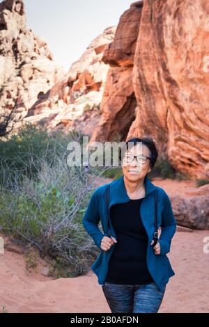 Portrait de la femme asiatique senior qui fait de la randonnée dans le paysage du désert Banque D'Images