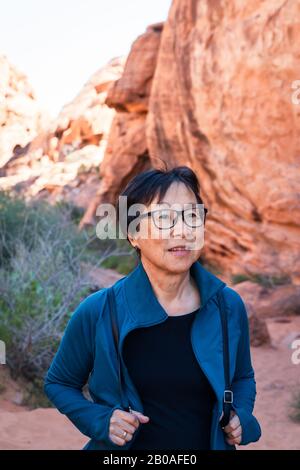 Portrait de la femme asiatique senior qui fait de la randonnée dans le paysage du désert Banque D'Images