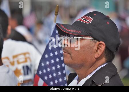 Homme hispanique senior avec drapeau américain et casquette de baseball chapeau de San Francisco lors du rallye Banque D'Images