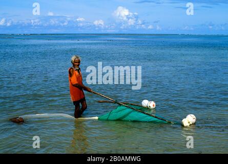 INDONÉSIE, SAWU (SEBA) PÊCHEUR DE L'ÎLE RAFLANT NET SUR FOND EN EAU PEU PROFONDE Banque D'Images