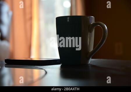 RÔTI DU DIMANCHE : une tasse de café fraîchement préparée repose sur une table de salon. Banque D'Images