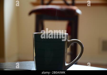 RÔTI DU DIMANCHE : une tasse de café fraîchement préparée repose sur une table de salon. Banque D'Images