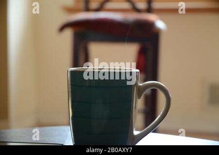 RÔTI DU DIMANCHE : une tasse de café fraîchement préparée repose sur une table de salon. Banque D'Images