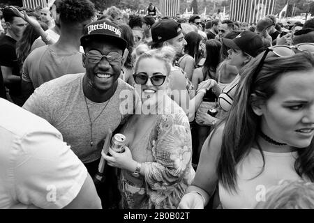 Couple mixte de course mosshing dans la foule de danse et posant pour une photographie sociale - Documenter un festival de musique Sydney, Australie Banque D'Images