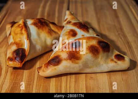 Sfiha, sorte de pie comme originaires de Syrie et du Liban et largement consommée dans le monde entier, sur une table en bois rustique. Banque D'Images