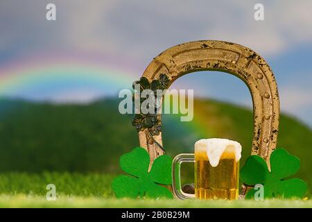 Plein air Lucky Horseshoe Arch et trèfle, tasse de bière dans herbacé, prairie verte Banque D'Images