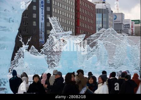 JAPON, ÎLE D'HOKKAIDO, SAPPORO, FESTIVAL DE LA NEIGE DE SAPPORO, LES GENS REGARDANT DES SCULPTURES DE GLACE Banque D'Images