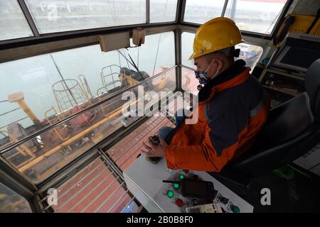 Hefei, Province Chinoise D'Anhui. 19 février 2020. Un travailleur exploite une grue pour soulever un conteneur au terminal international de conteneurs du port de Hefei à Hefei, dans la province d'Anhui, en Chine orientale, le 19 février 2020. Le port de Hefei a repris ses activités de manière ordonnée en vertu de mesures strictes prises pour prévenir et contrôler la nouvelle maladie du coronavirus (COVID-19). Crédit: Zhou Mu/Xinhua/Alay Live News Banque D'Images