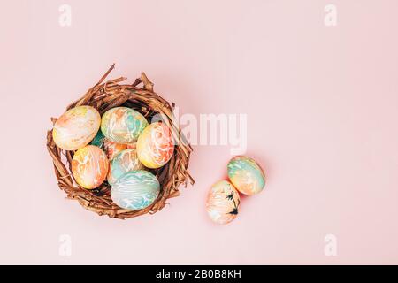 Des œufs de pâques dans le nid avec des tons roses pastel. Banque D'Images