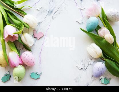 Bouquet d'œufs de Pâques et de tulipes sur fond de marbre blanc Banque D'Images