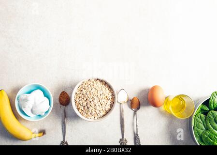 Ingrédients pour des crêpes vertes saines comme les épinards, le lait de coco, la banane, l'oeuf et l'avoine. Petit-déjeuner végétarien et sans gluten Banque D'Images