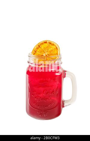 Un cocktail transparent de couleur unique, du thé froid, rafraîchissant dans un pot en verre avec des glaçons, des chips de tranches d'orange, du citron et du goût des baies, de la graisse, du S Banque D'Images