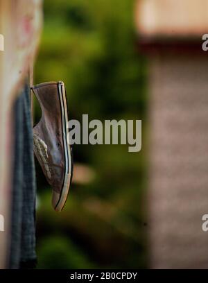 Les vieilles chaussures pendaient d'un balcon pour sécher, mais on aurait l'impression qu'elles étaient là depuis longtemps. Toujours la vie, toujours la photographie Banque D'Images