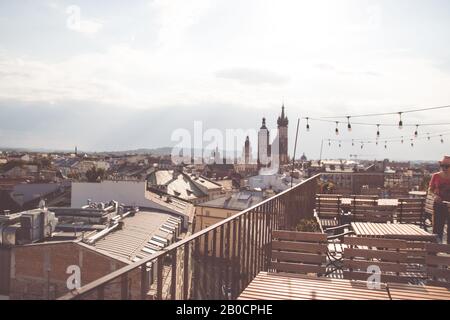 Vue sur la ville depuis le toit, café sur le toit. Tables et chaises en bois. Cracovie, Pologne Banque D'Images