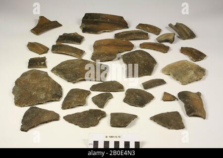 Barards lâches appartenant à un pot de cuisine d'argile cuite au four. Le pot de cuisine a des épaules rondes élevées et un bas col concave. L'arête est aplatie à l'extérieur. Un certain nombre de barards n'appartiennent pas au pot de cuisson (y compris un fragment d'une poignée et 2 fragments de bord). Fabriqué sur la roue. L'argile est brun-gris, a une texture moyenne et est tempérée par quartzite. La surface est recouverte d'un revêtement marron et contient du gris foncé Banque D'Images