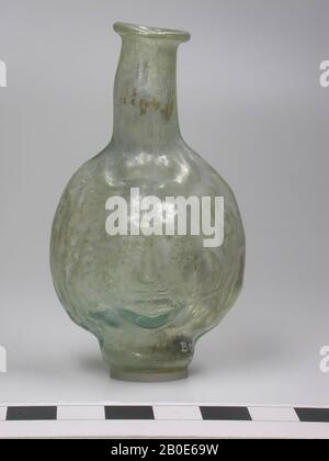Bouteille à parois minces pour tasse de Janus pour le parfum. De deux moitiés de verre incolore à vert soufflé, ajouter visible. Bord à col plat et col soufflé libre légèrement coulé. Douille de torus, plate au fond, des bouteilles sous forme de visage humain apparaissent pour la première fois dans la AD du 2ème siècle. Ils sont soufflés dans une forme et ont généralement la caractéristique d'une 'tête janus', un visage sur le devant et le dos. Rarement les vases qui ont été élaborés comme une tête autour., vaisselle, verre, H 8 cm, Russie Banque D'Images