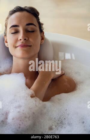 Young woman relaxing in bathtub Banque D'Images