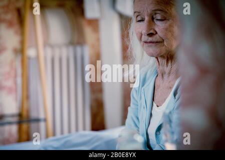 Senior woman sitting on bed Banque D'Images