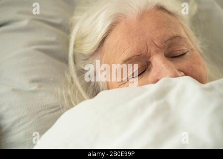 Woman sleeping on bed Banque D'Images