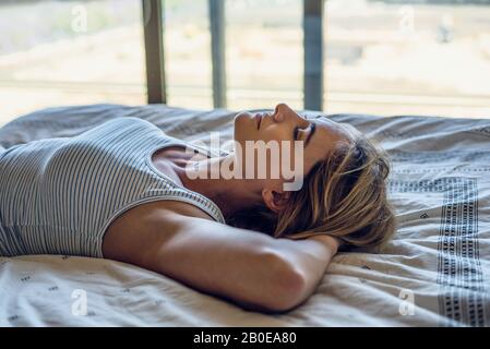 Young woman sleeping on bed Banque D'Images