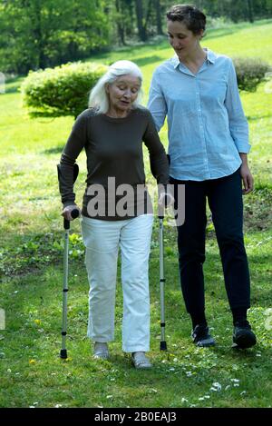 Soignant et femme senior marchant dans le jardin Banque D'Images