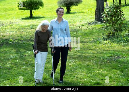 Soignant et femme senior marchant dans le jardin Banque D'Images